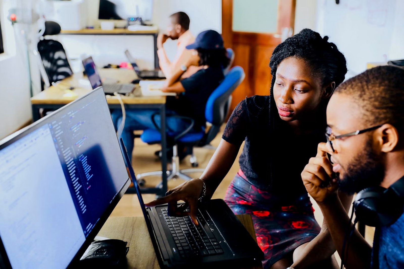 Professionals collaborating around laptops in a modern office